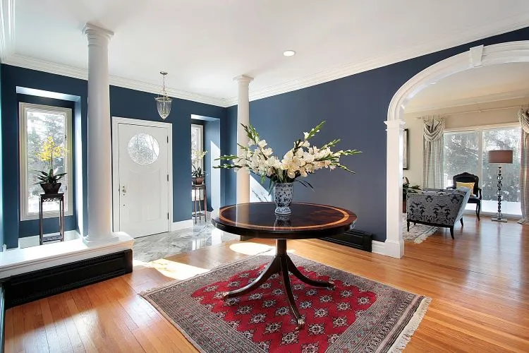 Elegant foyer with rich blue accent walls and white trim