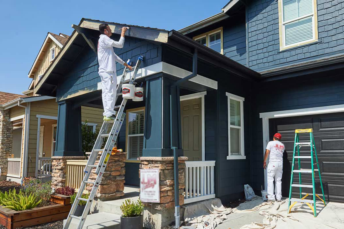 Residential exterior repaint with deep blue siding and white trim